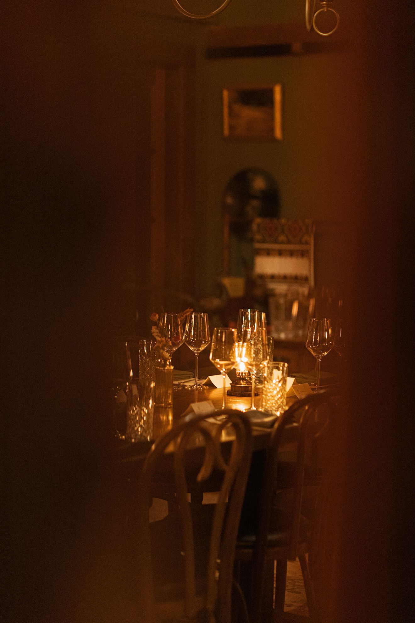 A long table with a lot of glasses on it in a dark room.