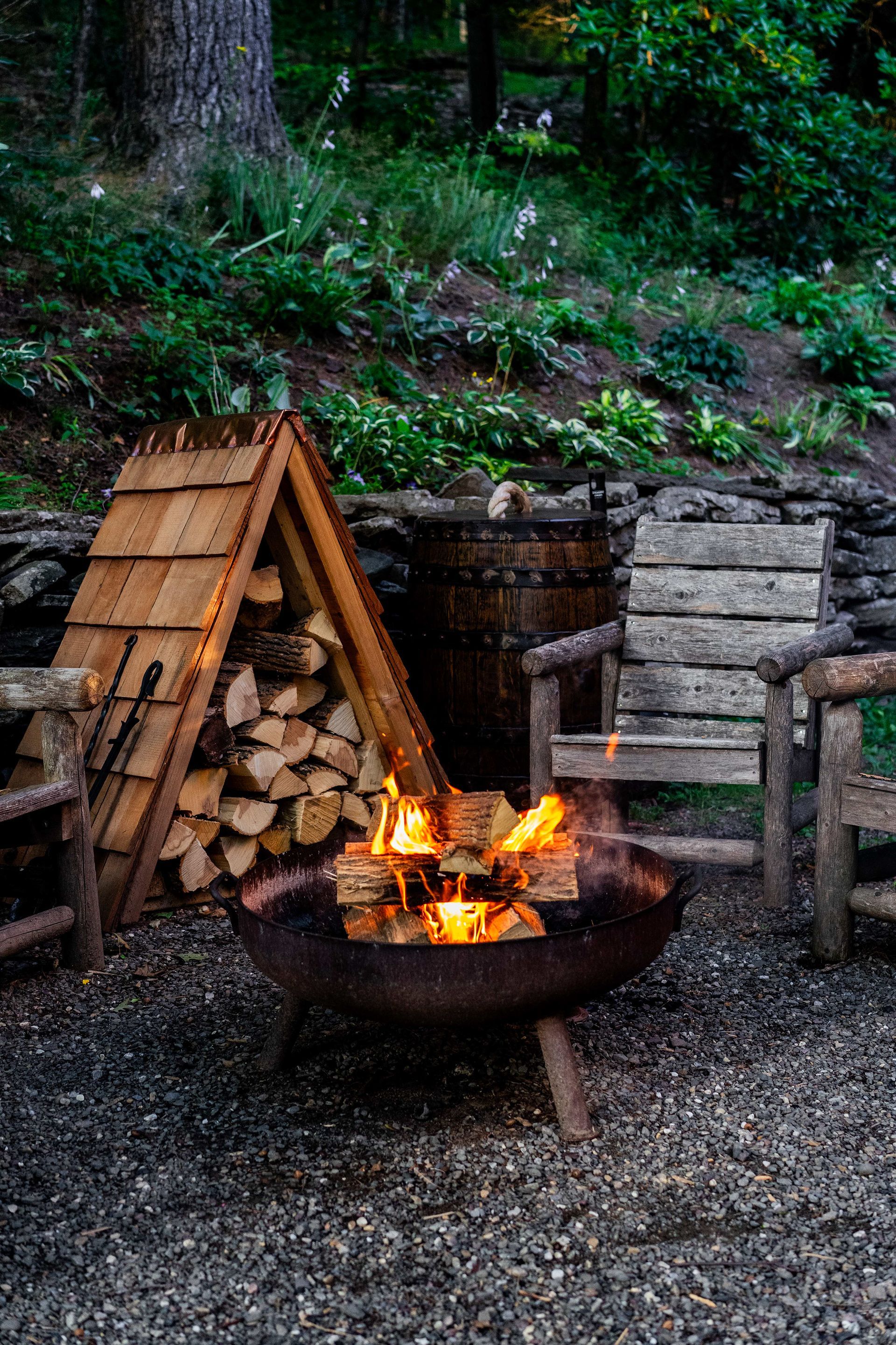 There is a fire pit in the middle of the woods.