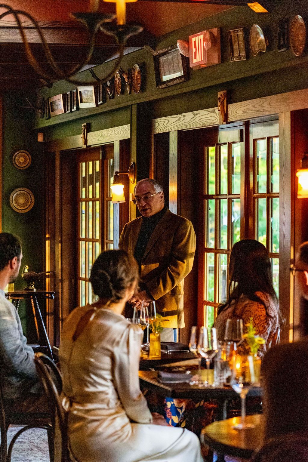 A man is giving a speech to a group of people at a restaurant
