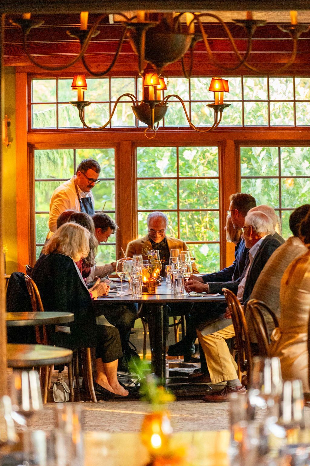 A group of people are sitting at tables in a restaurant.