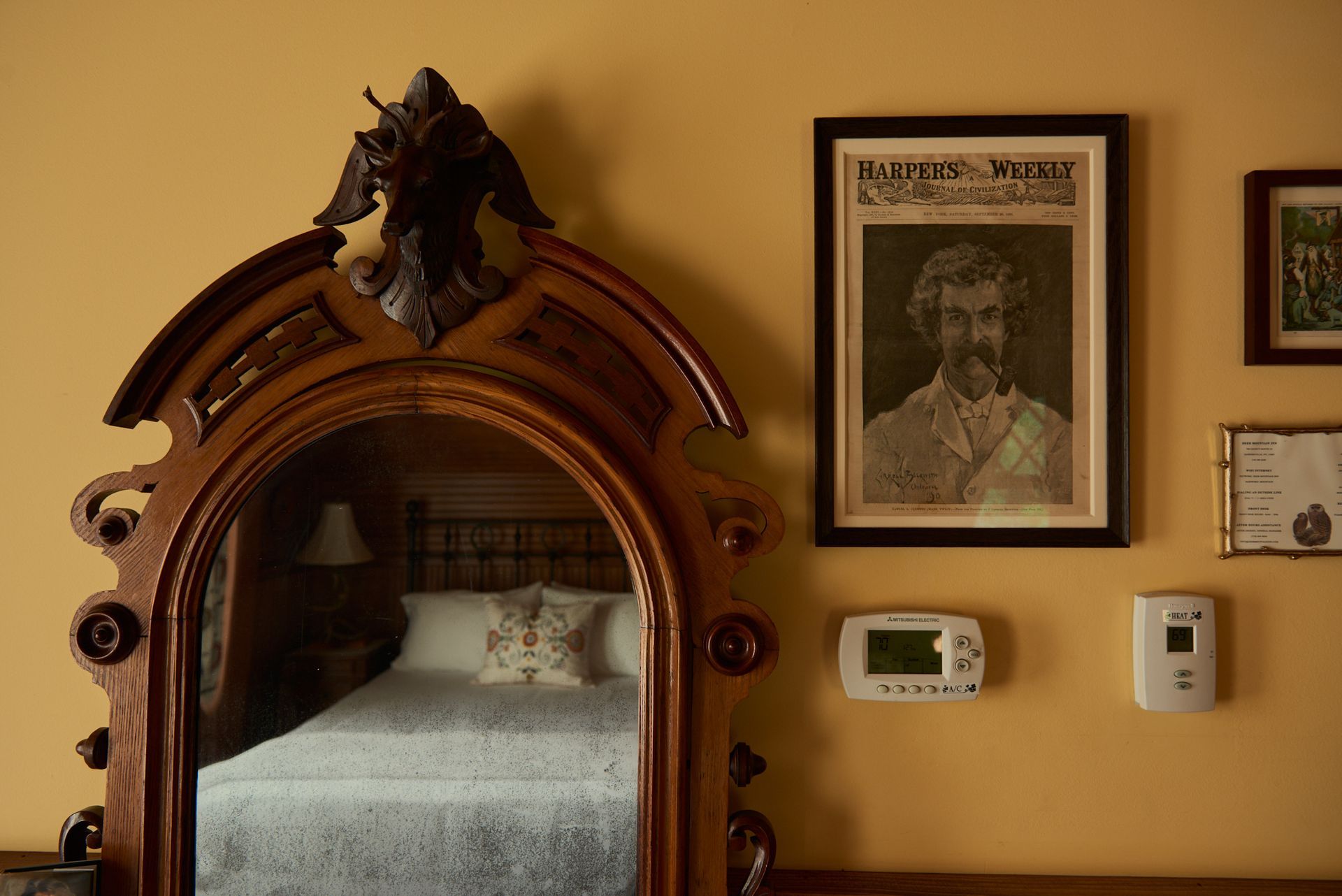 A bedroom with a mirror and a picture on the wall