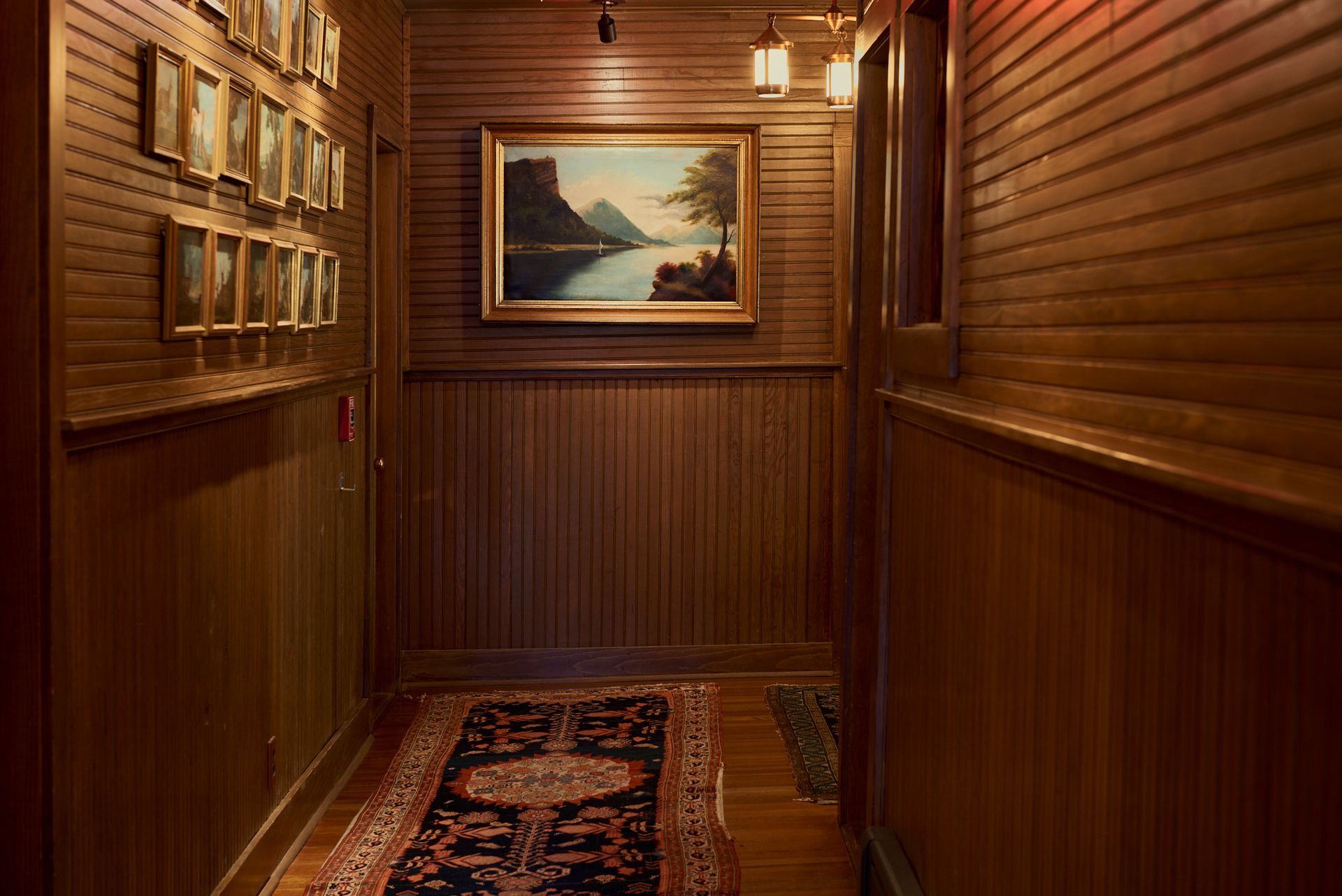 A hallway with wood paneling and a painting on the wall