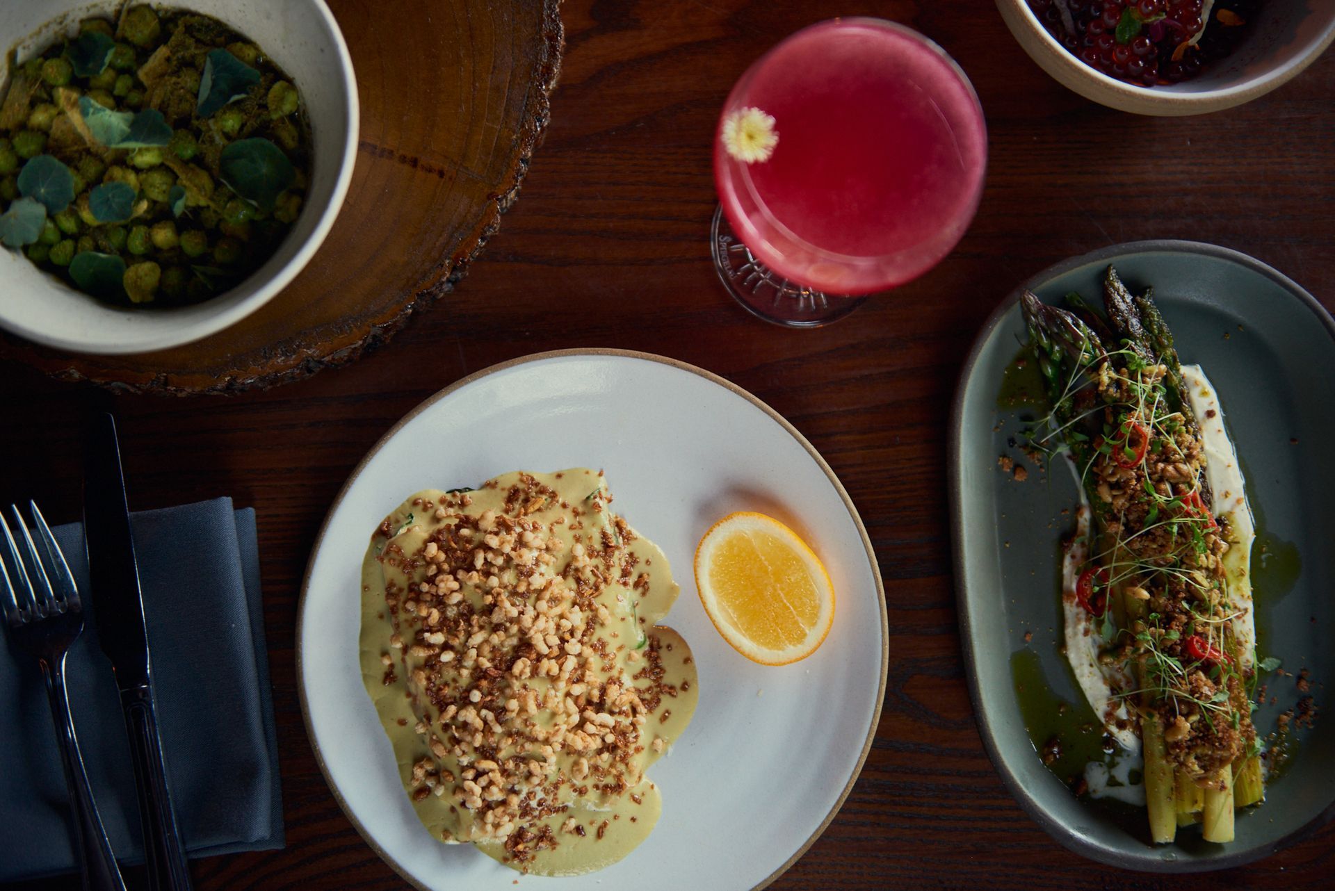 A table topped with plates of food and a drink.