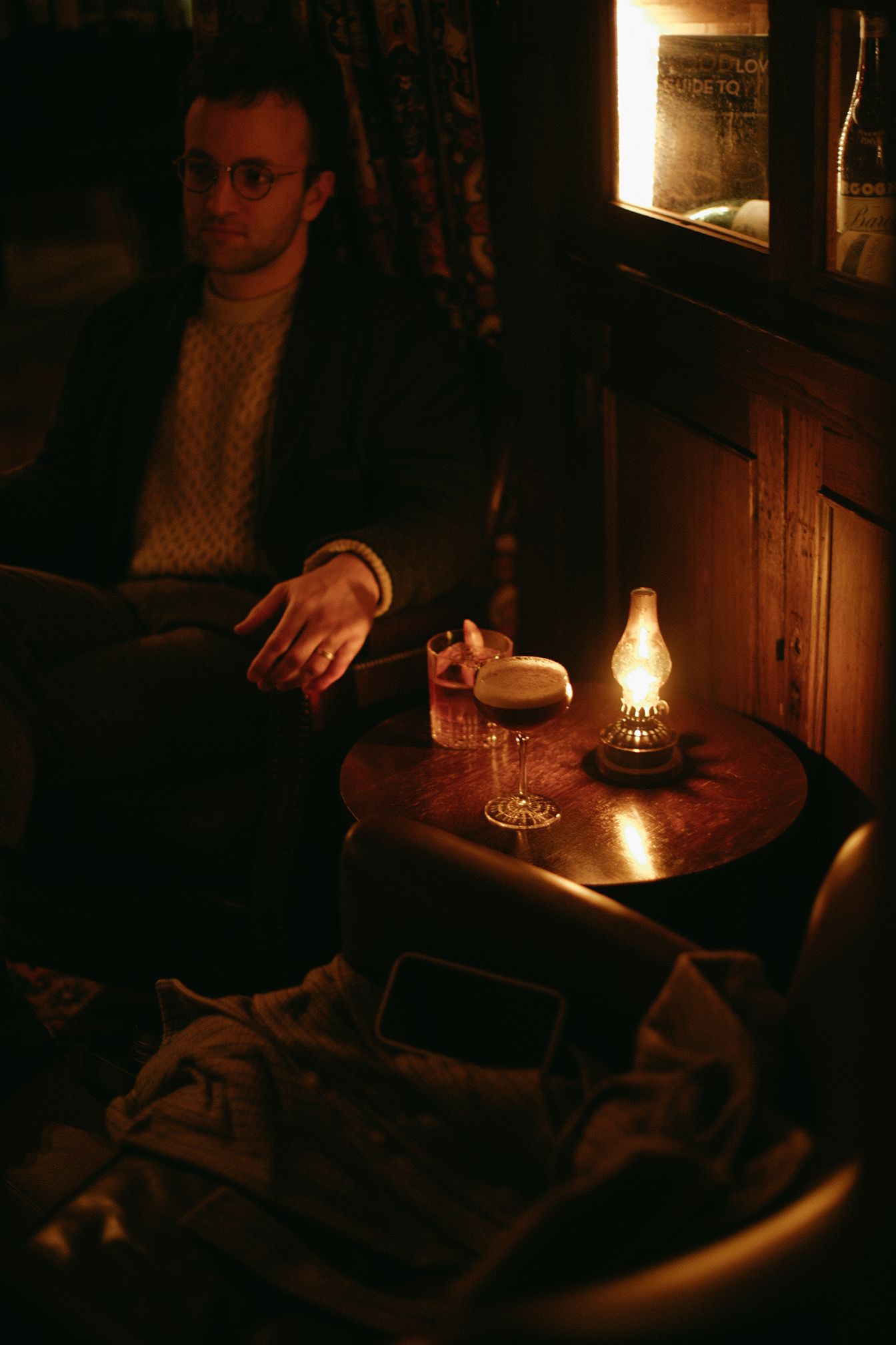 A man is sitting at a table with a lamp on it