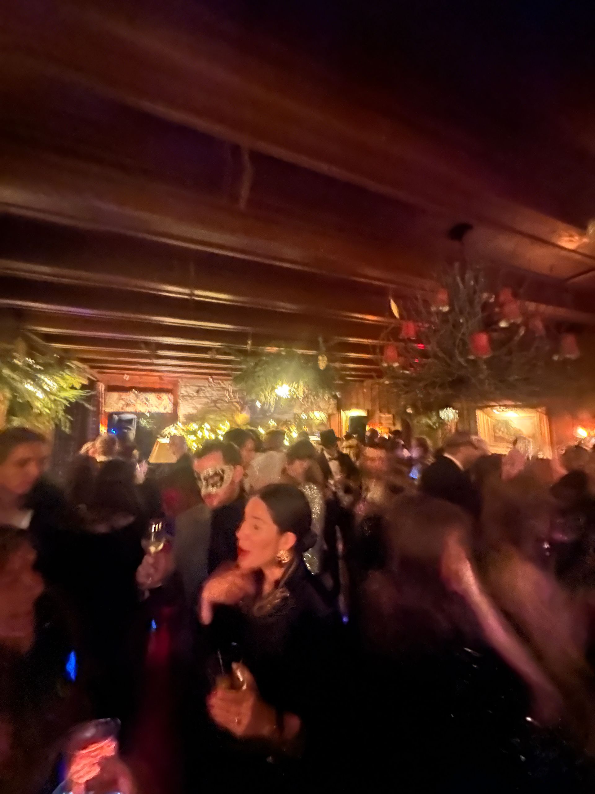 A crowd of people are dancing in a dark room.