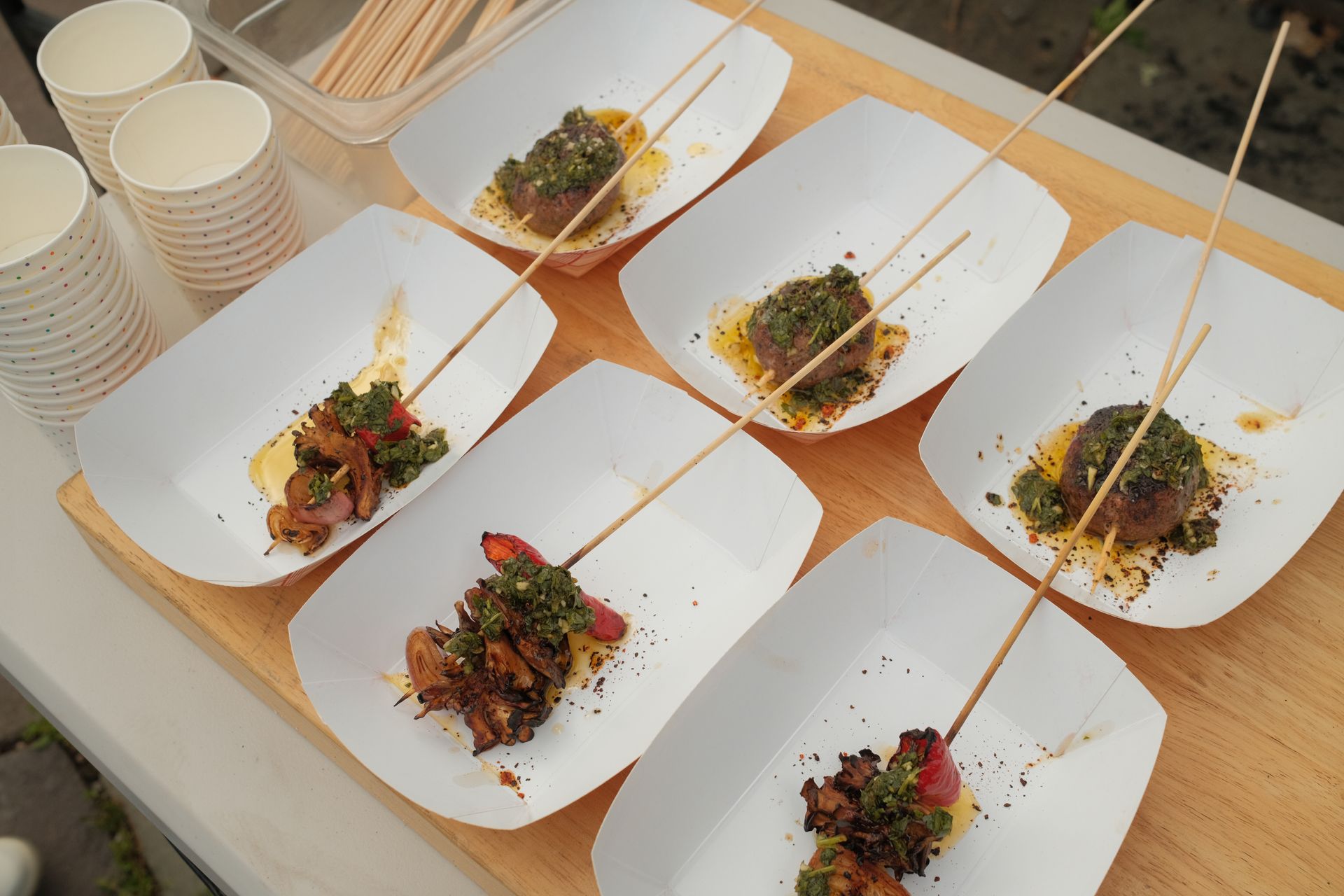 A bunch of plates of food on sticks on a table