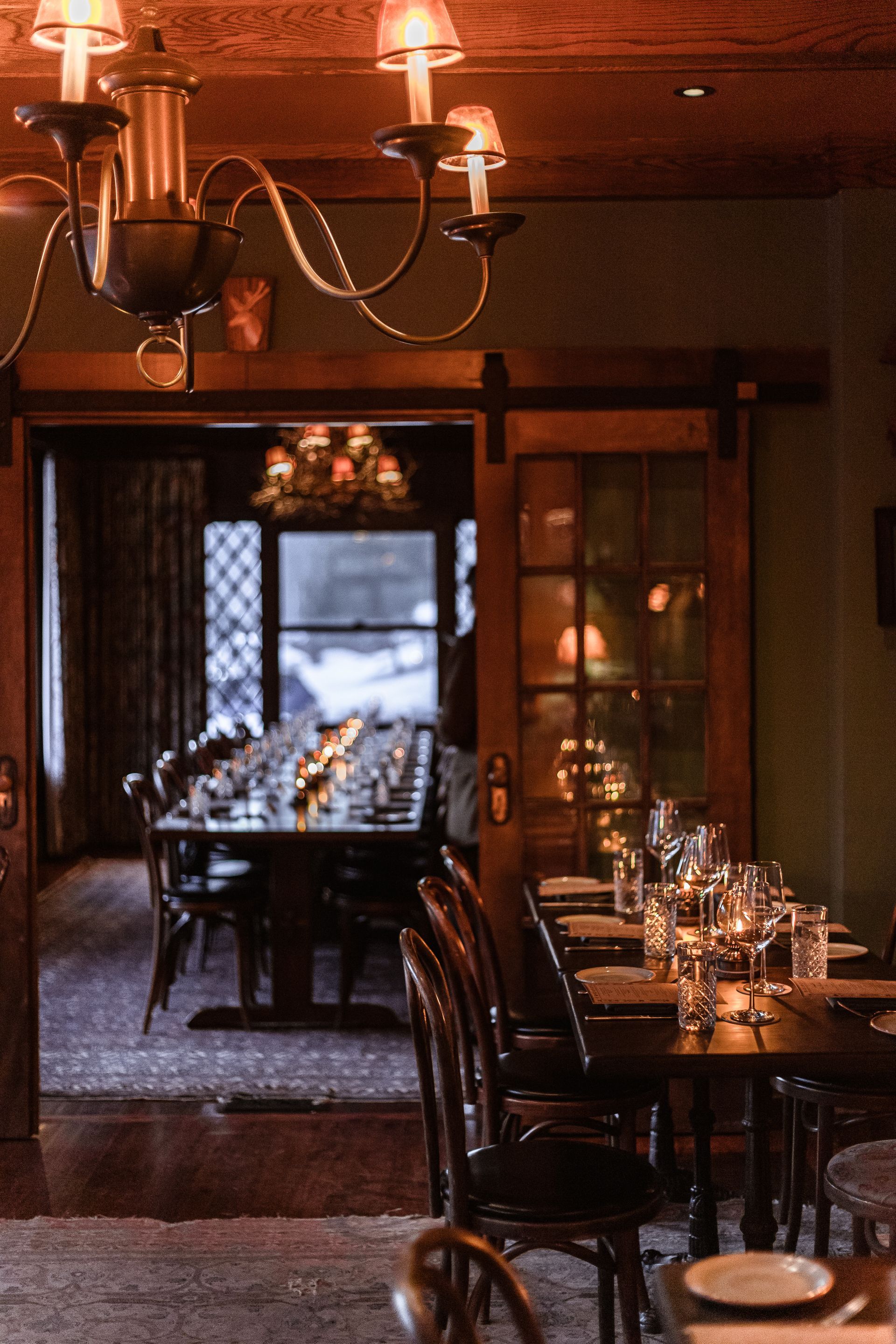 A dining room with tables and chairs and a chandelier