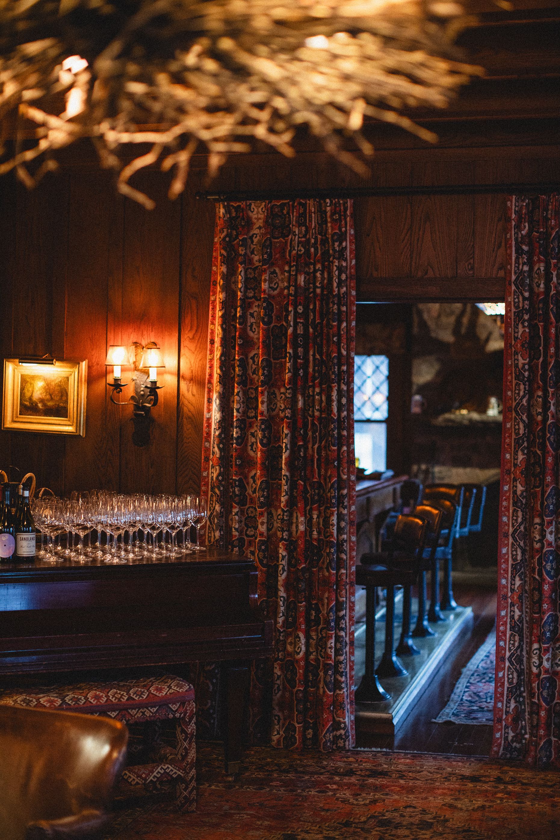 A room with a bar and a lot of wine glasses on it.
