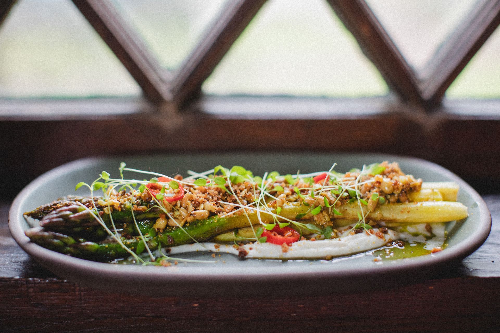 A plate of food is sitting on a table in front of a window.