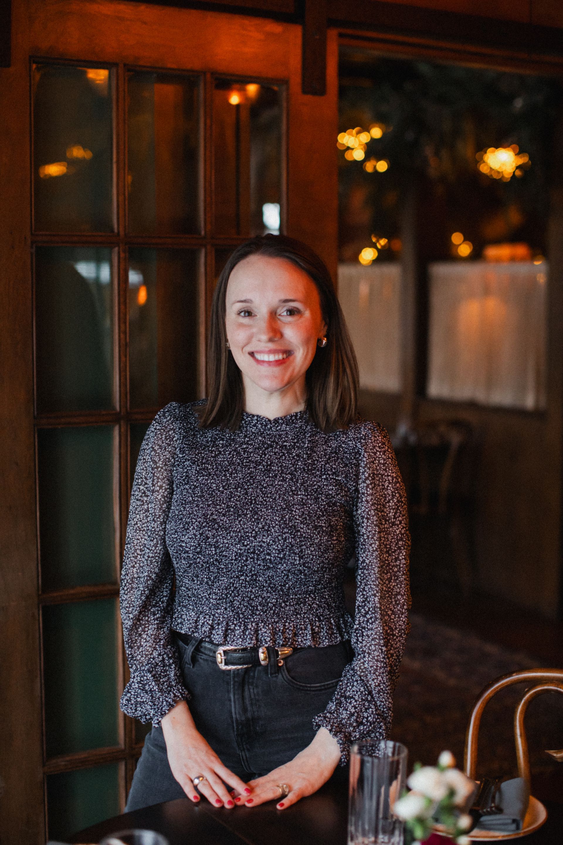 A woman is standing in front of a door in a restaurant.
