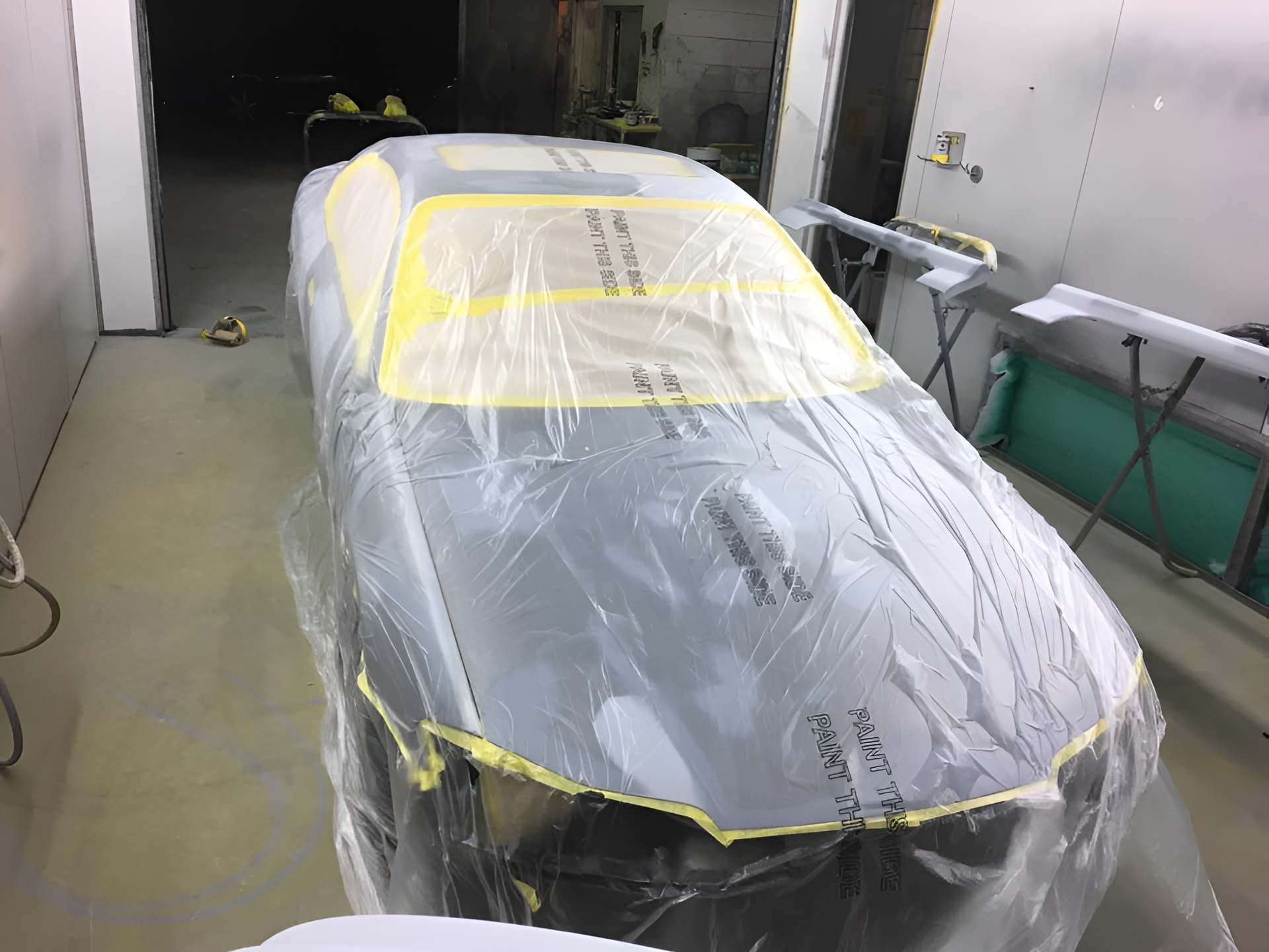 A Car is Covered in Plastic in a Paint Booth — C & C Panel & Paint Mackay In Mackay, QLD