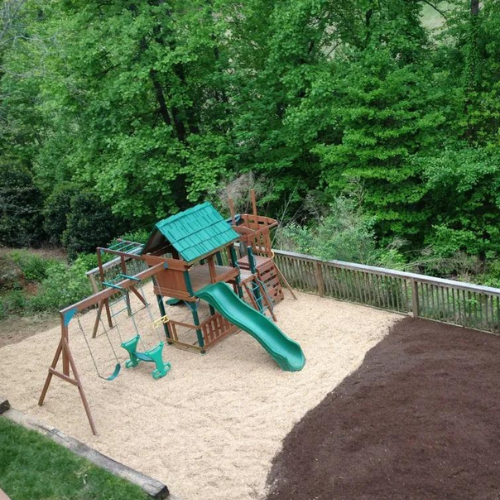 an aerial view of a playground with a slide and swings .