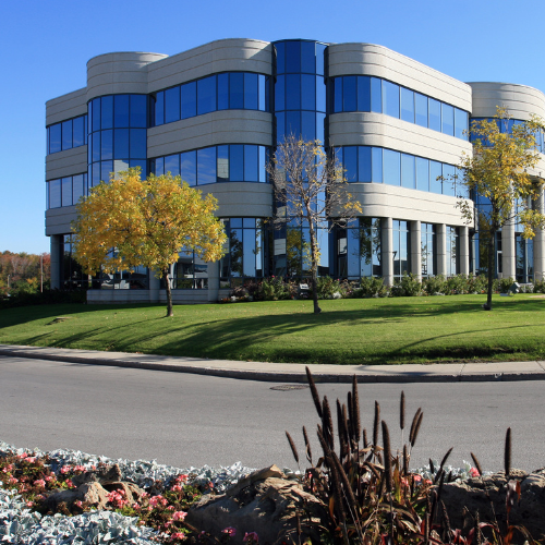 a large building with lots of windows and trees in front of it