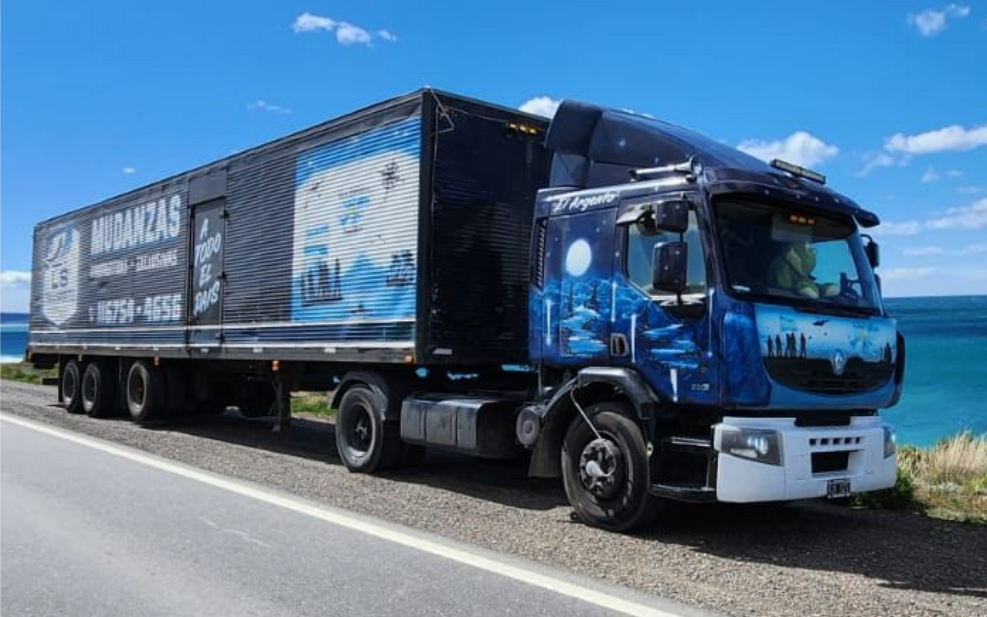 Camión Iveco azul estacionado bajo el letrero de Andreani en un muelle de carga.