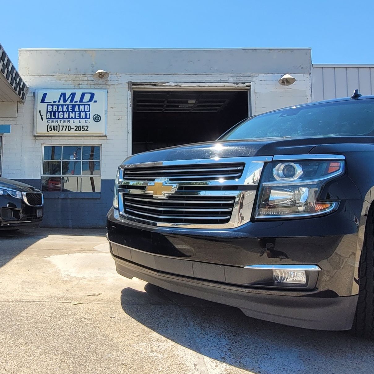 A Chevy Tahoe parked in front of LMD Brake & Alignment Center in downtown Medford, Oregon