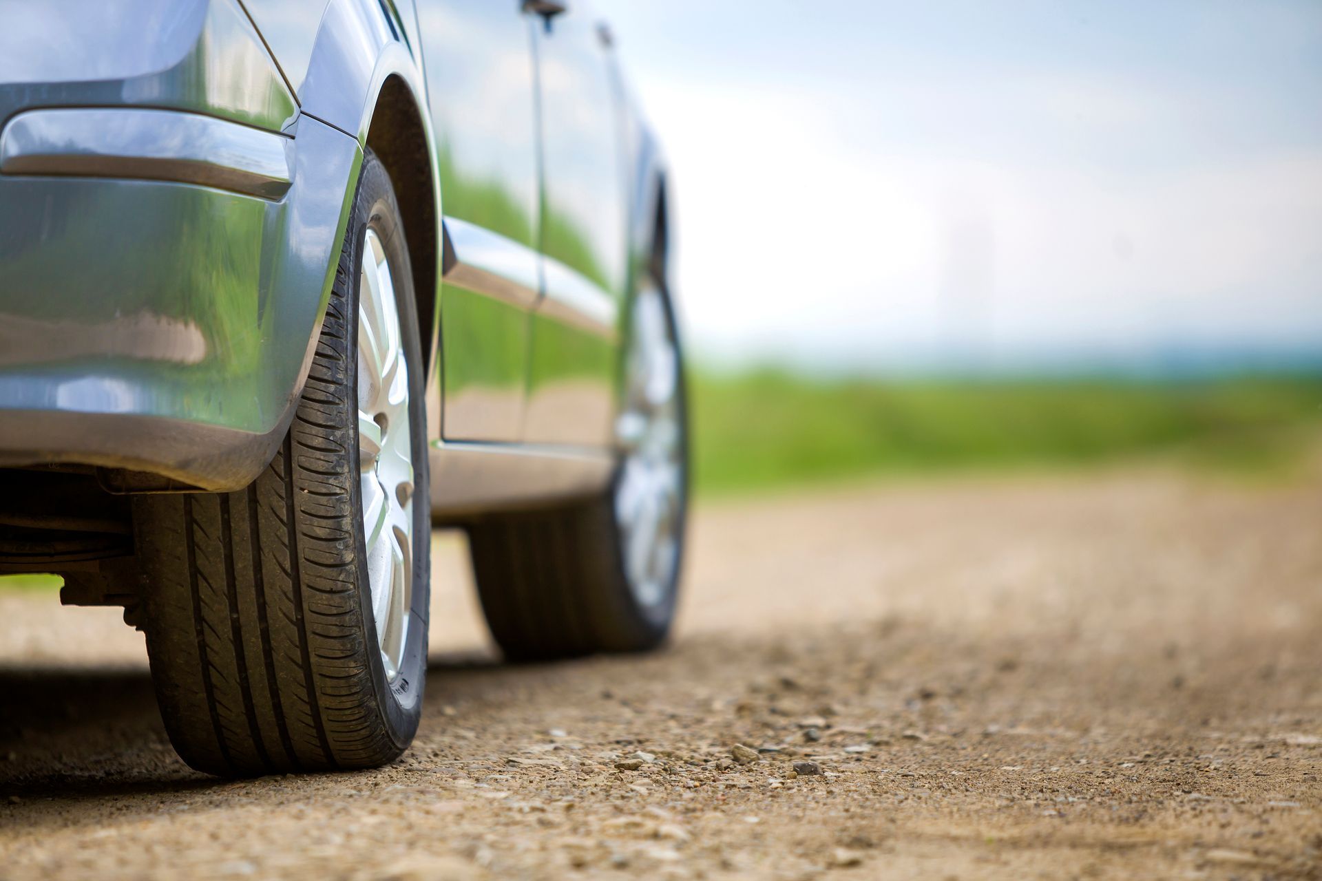 A car is parked on a dirt road.