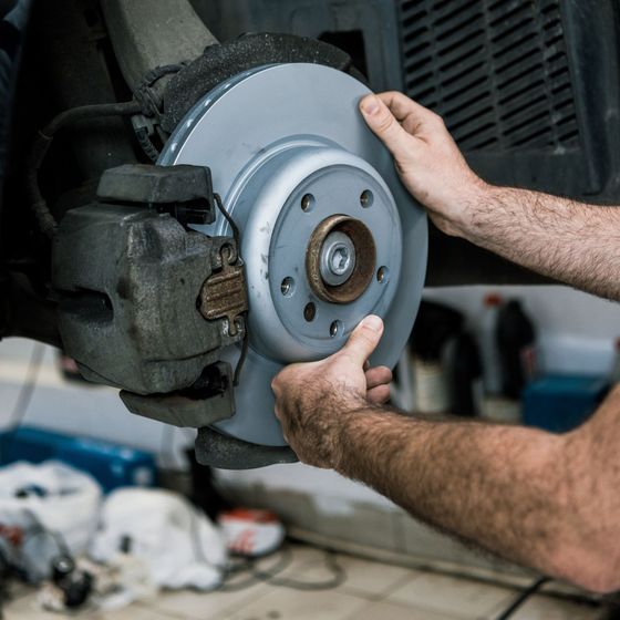 Auto mechanic is installing new brake rotors and pads on a car in Medford, Oregon.