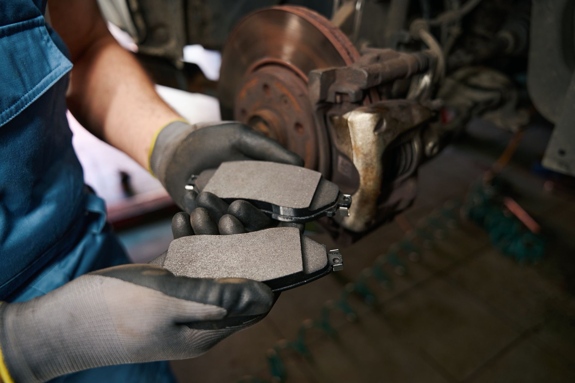 A close up of a person holding brake pads in their hands.