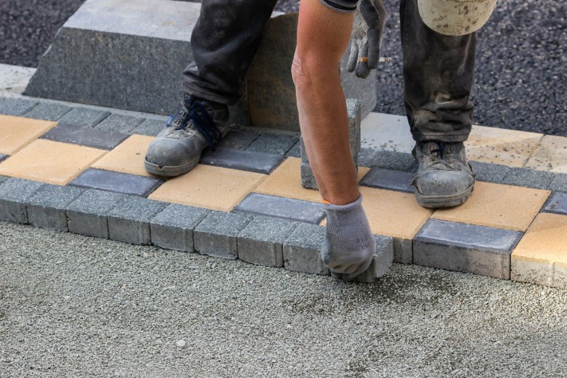 Photo of installer laying pavers in intricate pattern during paver installation