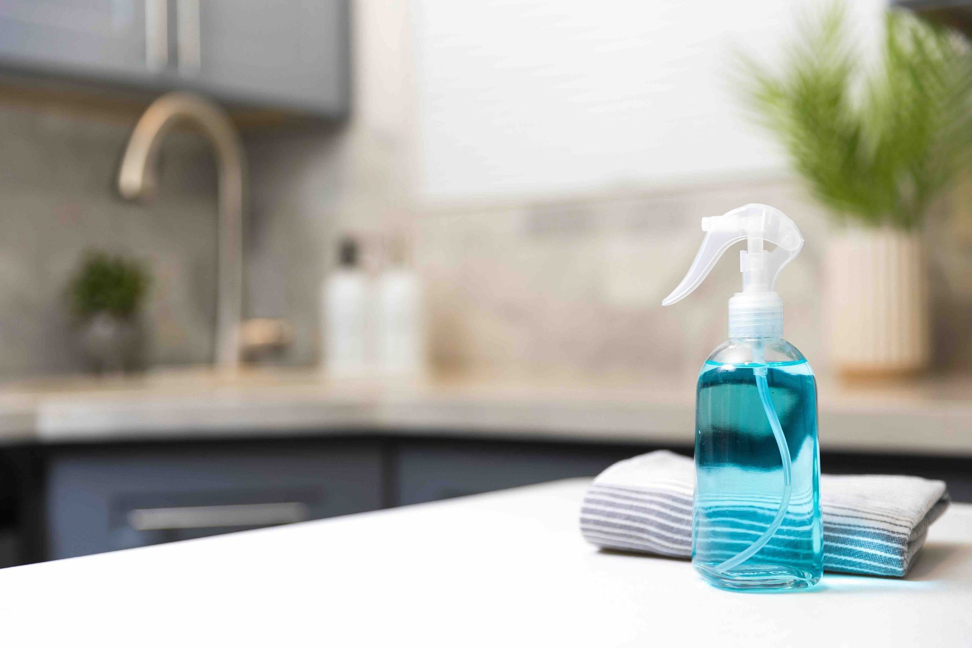 a spray bottle and a towel are on a kitchen counter.