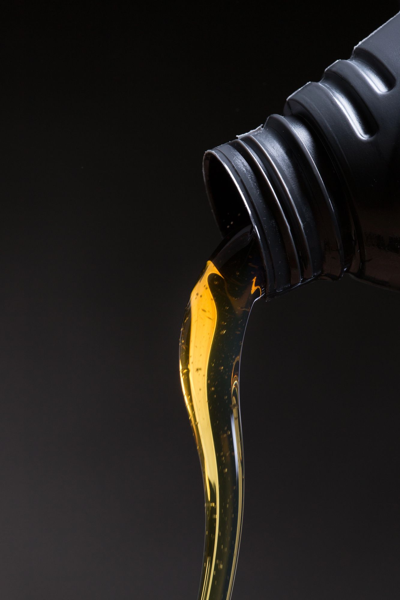 Un primer plano de una botella de aceite saliendo de ella.