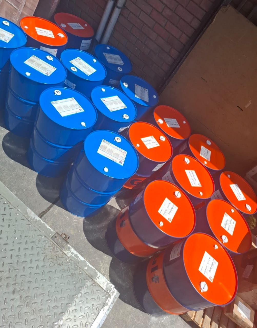 Un montón de barriles azules y naranjas apilados uno encima del otro.