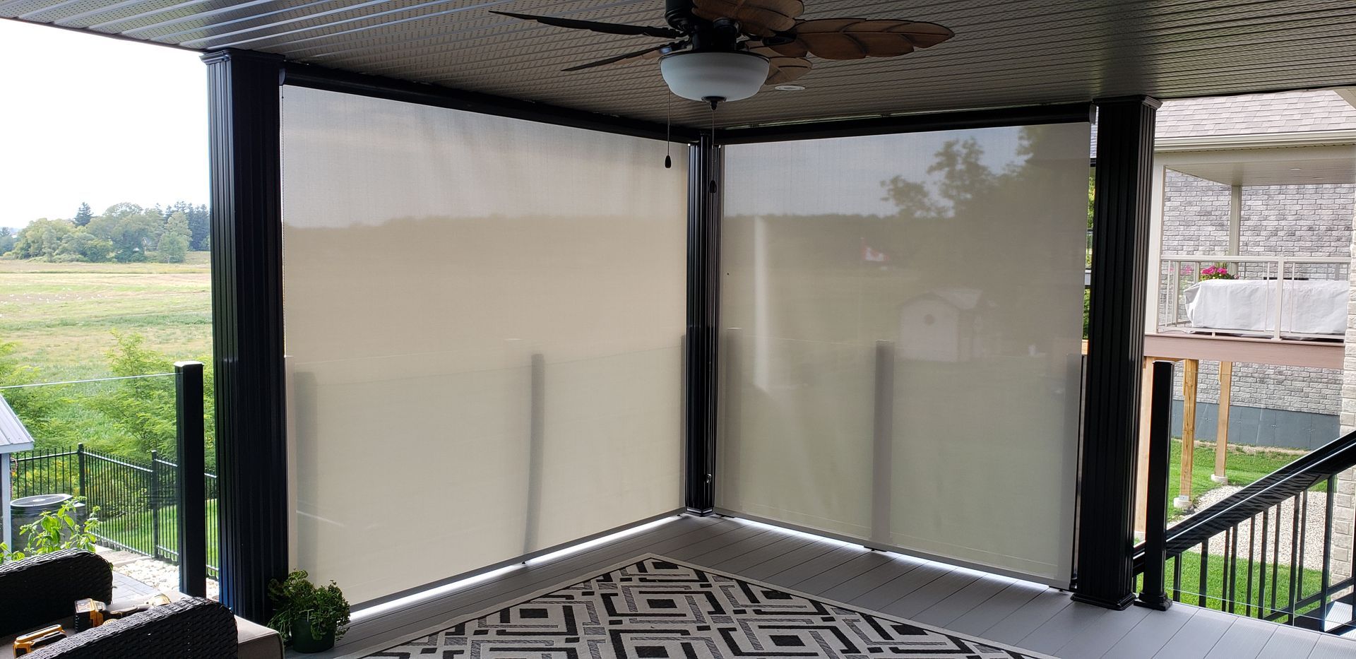 A porch with a ceiling fan and blinds on it.