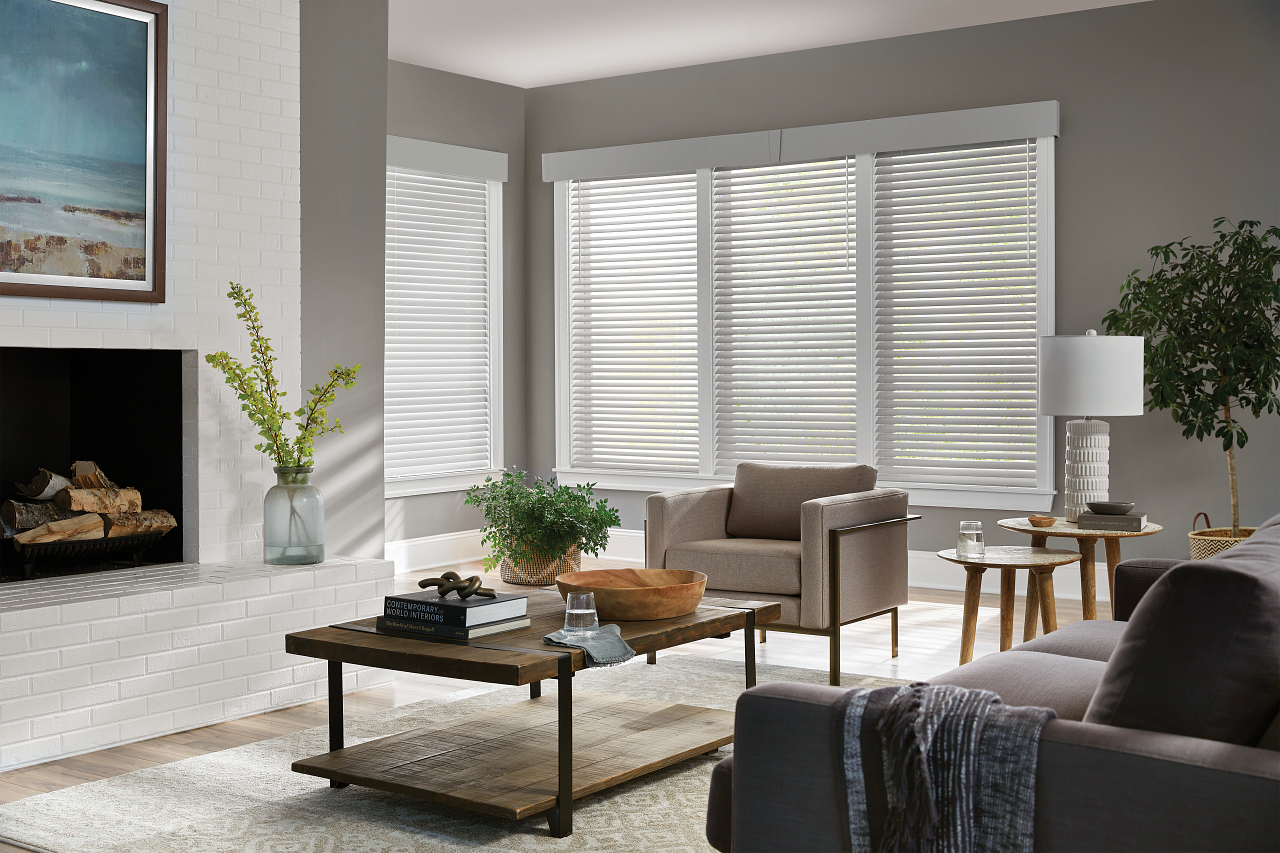 A living room with a couch , chair , coffee table and fireplace.