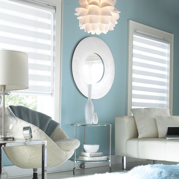 A living room with blue walls and white furniture