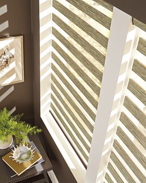 A room with a window and a table with a plant on it.