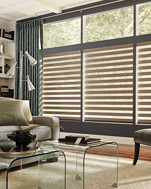 A living room with a couch , coffee table , and striped blinds.