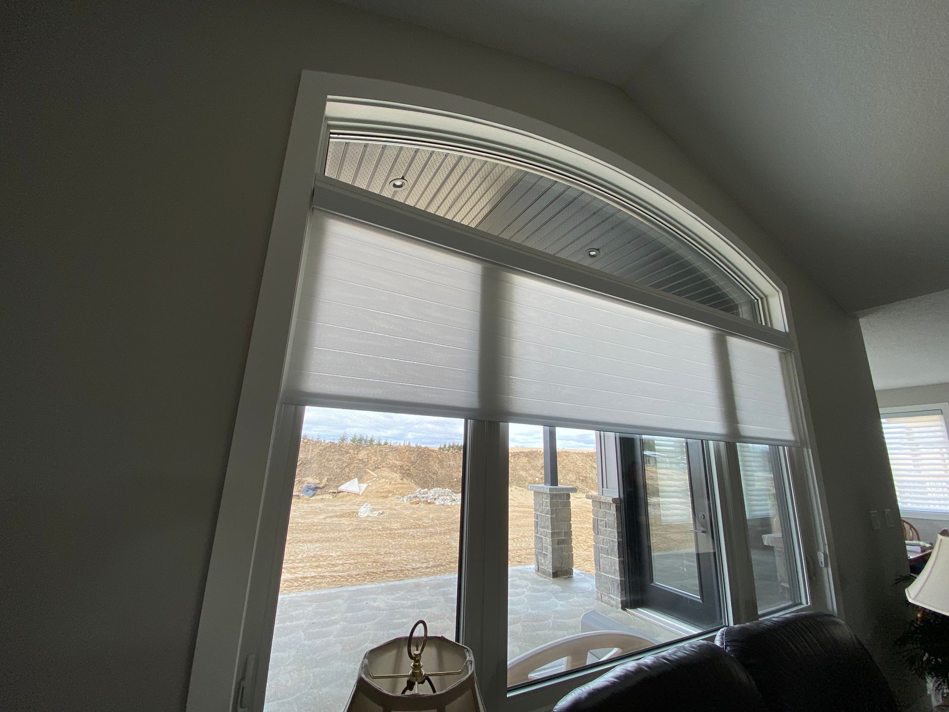 A living room with a large window and blinds on it.