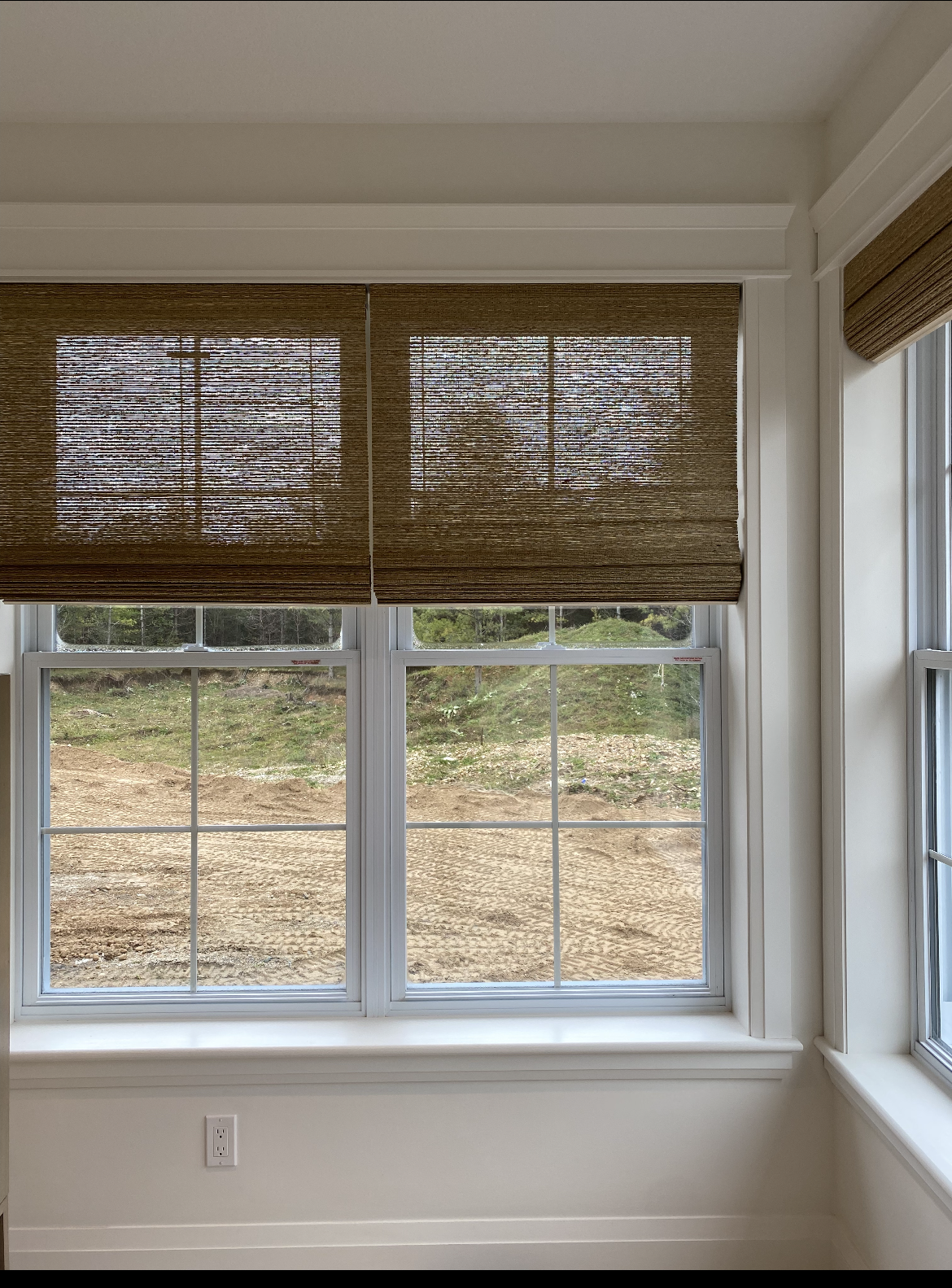 A window with blinds on it and a view of a field
