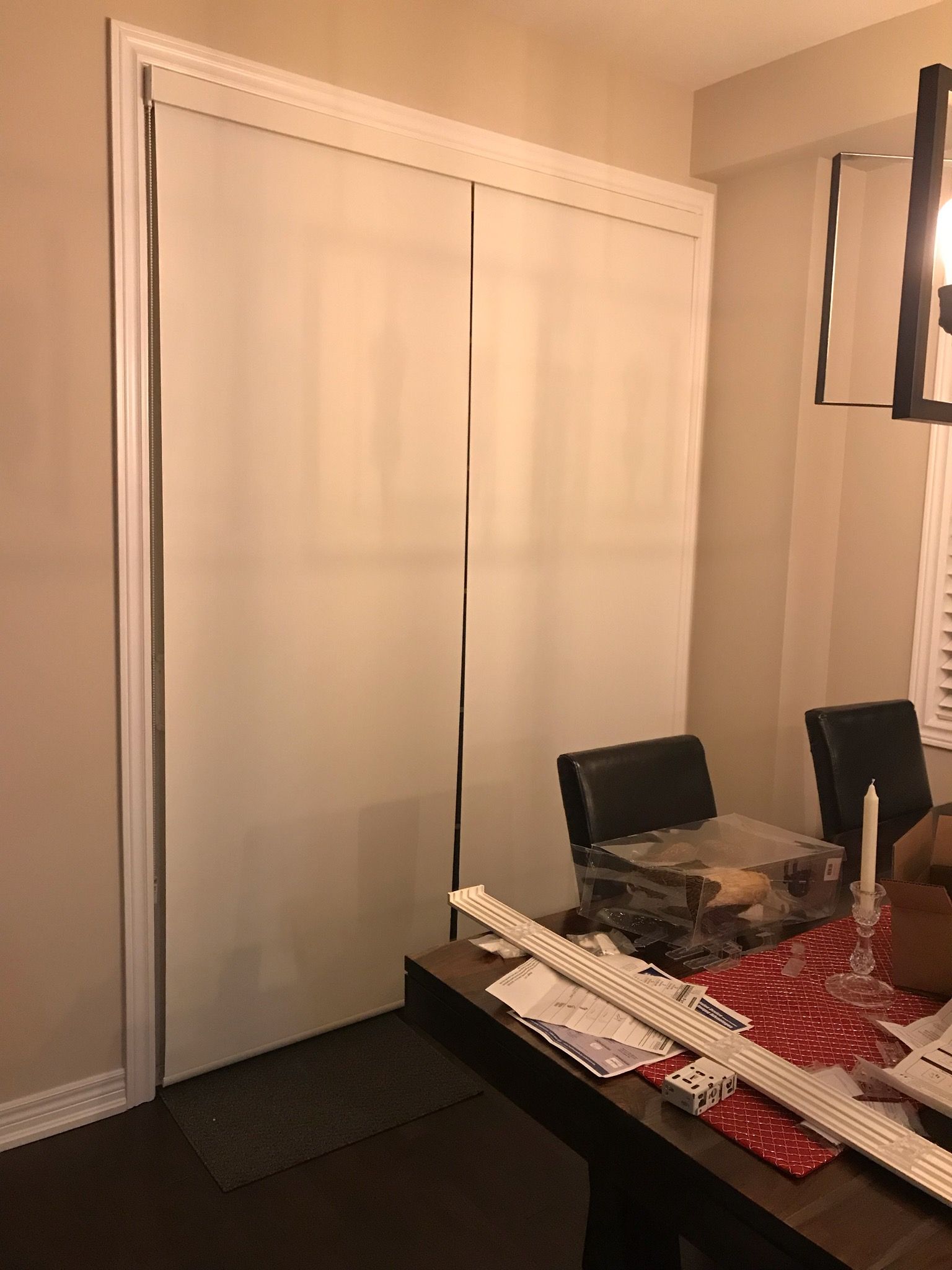 A dining room with a table and chairs and sliding glass doors.