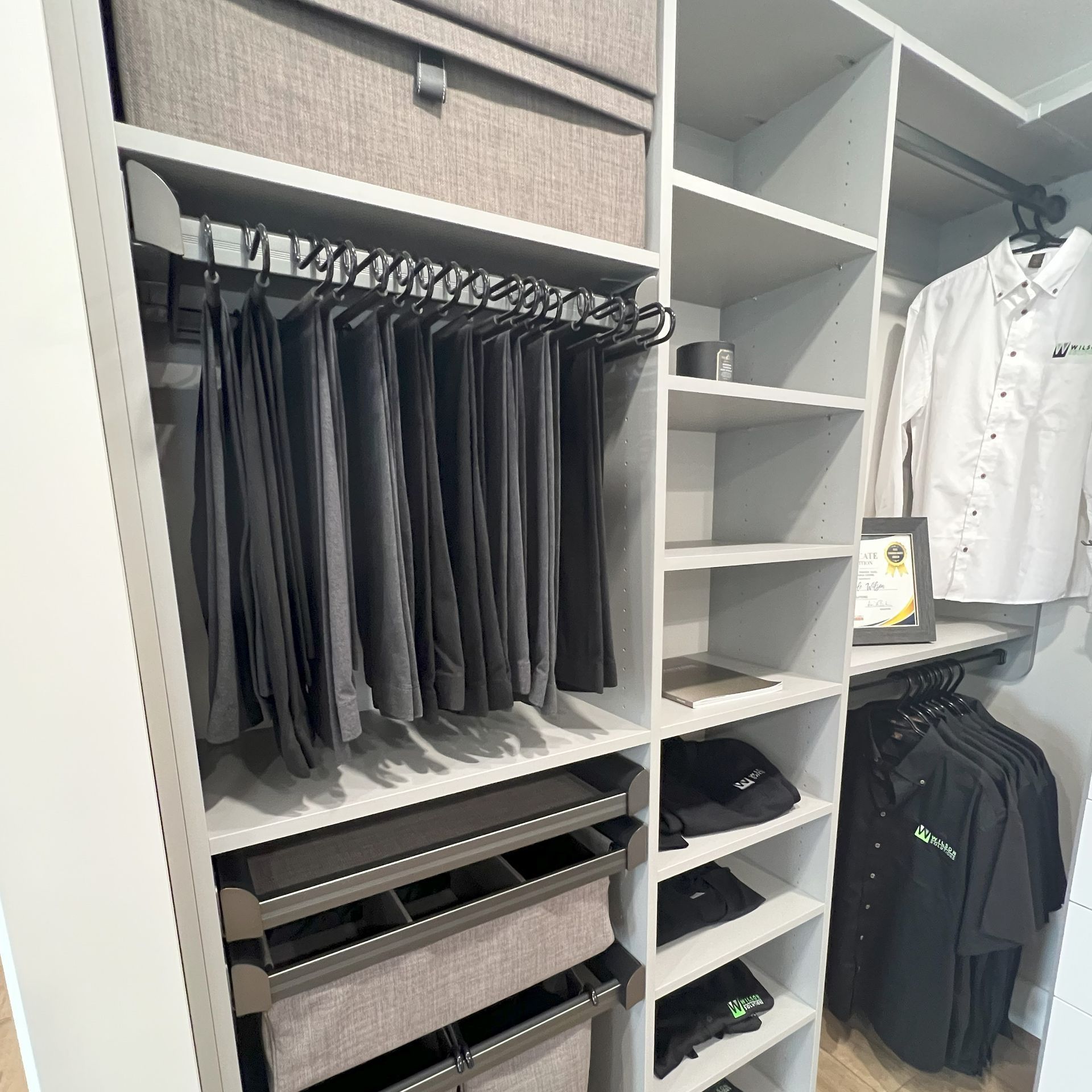 A walk in closet filled with clothes and hats.