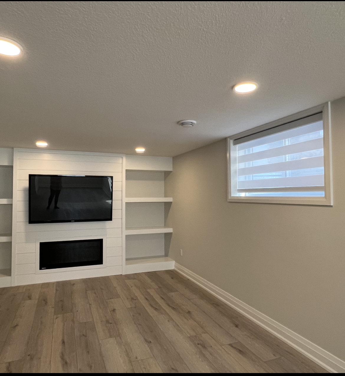 A living room with a flat screen tv on the wall
