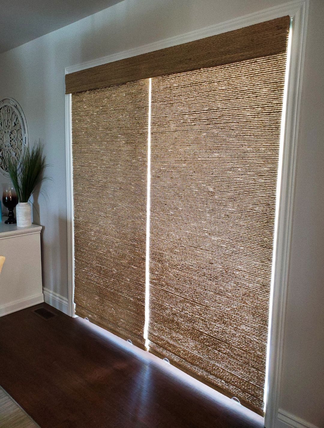 A living room with a sliding glass door with blinds on it.