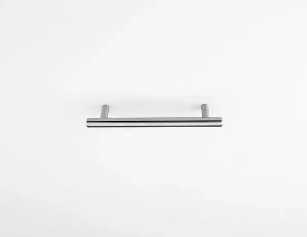 A stainless steel handle is sitting on a white surface.