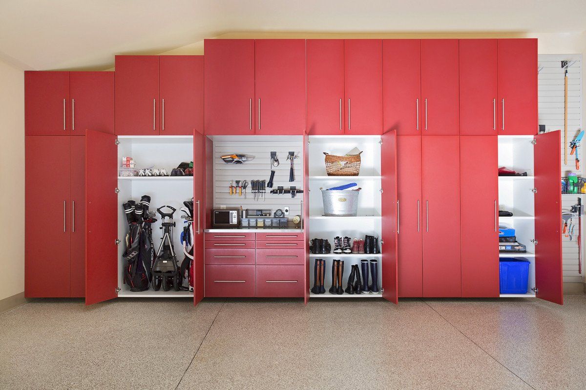 A garage filled with red cabinets and shelves.