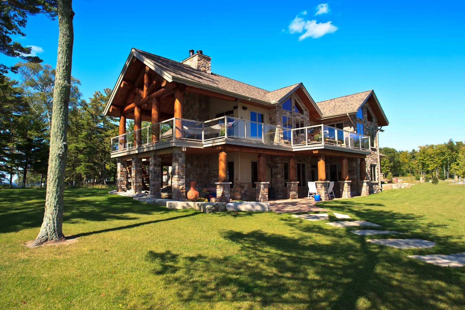 A large house is sitting on top of a lush green field.