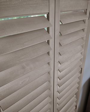 A close up of a pair of wooden shutters on a window.
