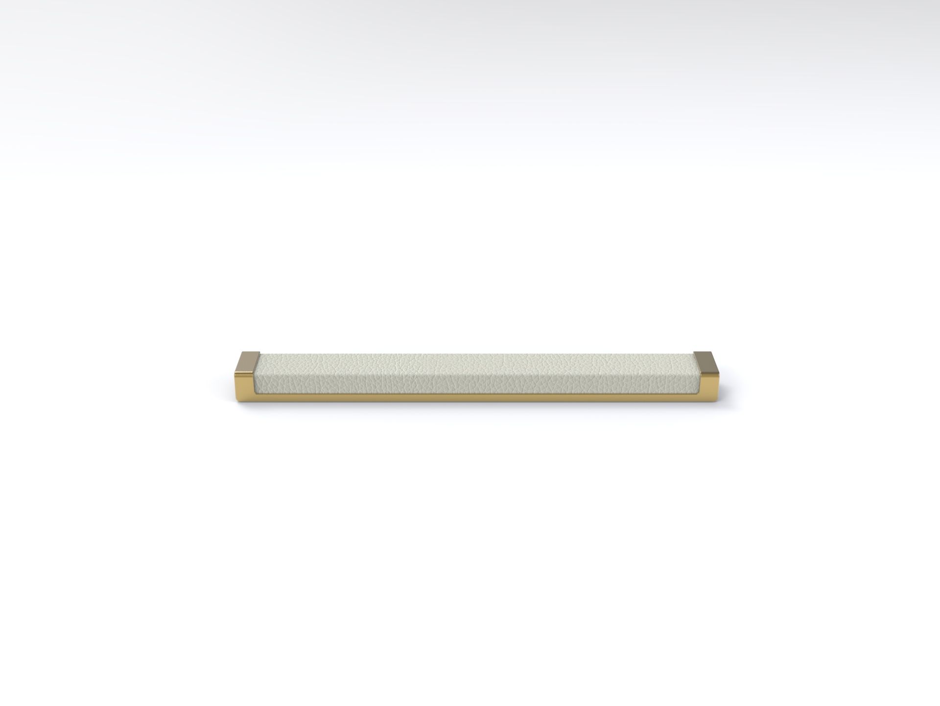 A brush with a brass handle is sitting on a white surface.