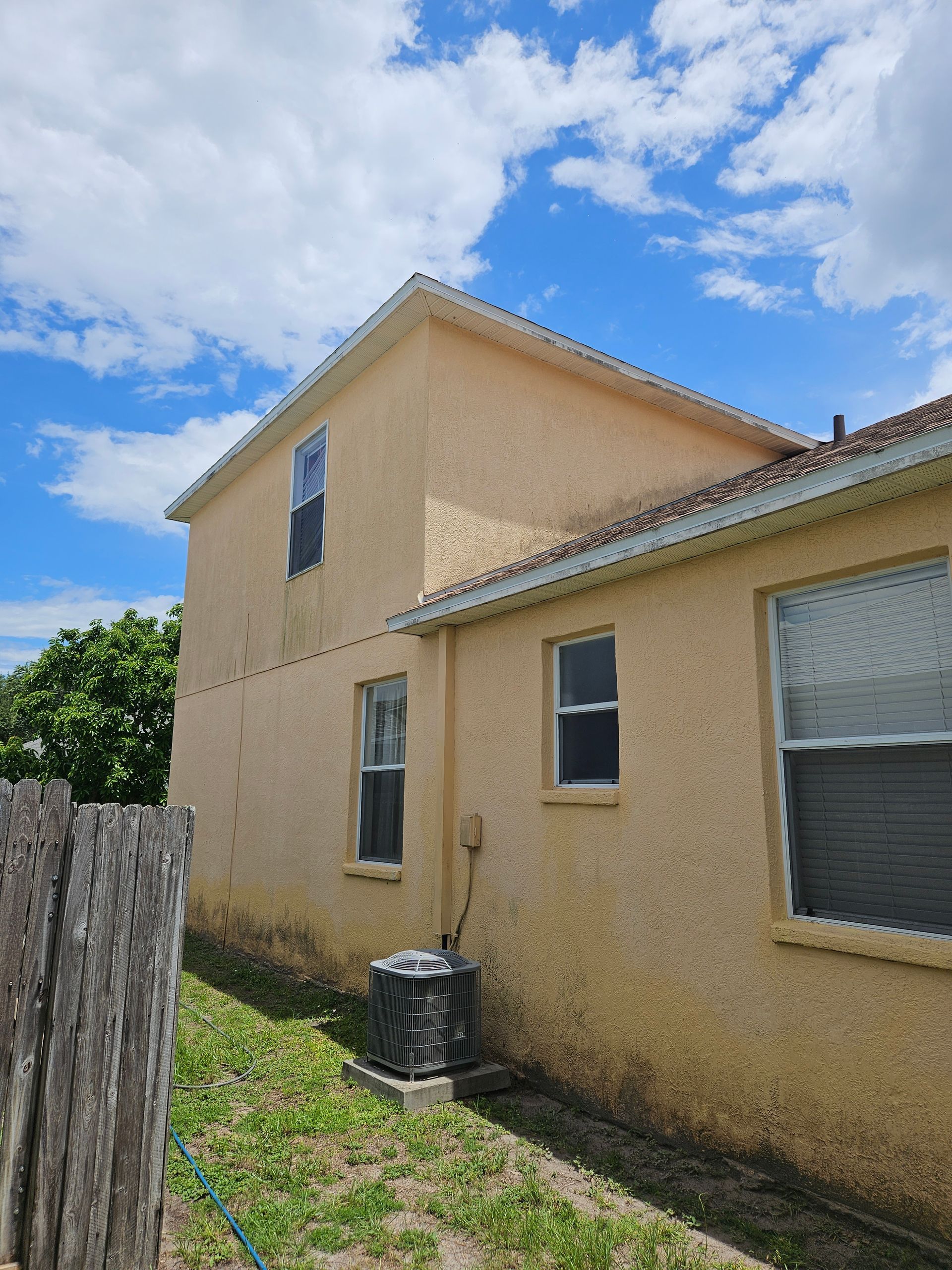 A house with a lot of windows and a fence in front of it