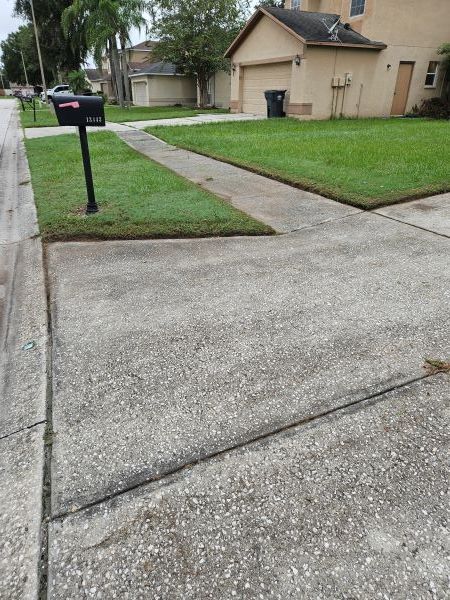A tan stucco exterior wall under a white roof eave against a vibrant blue sky with fluffy white clouds.