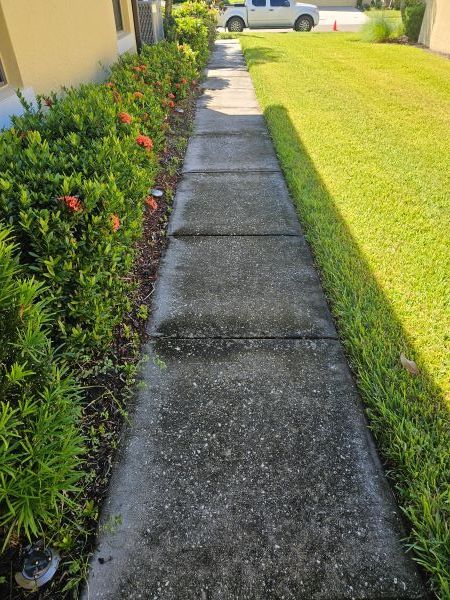 A tan stucco exterior wall under a white roof eave against a vibrant blue sky with fluffy white clouds.