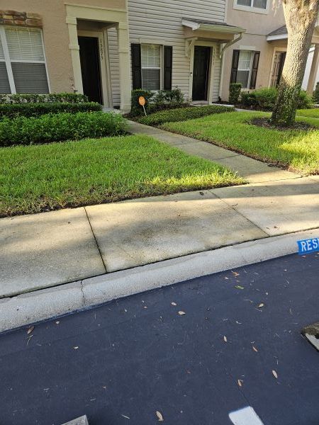 A tan stucco exterior wall under a white roof eave against a vibrant blue sky with fluffy white clouds.