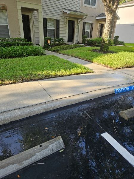 A tan stucco exterior wall under a white roof eave against a vibrant blue sky with fluffy white clouds.