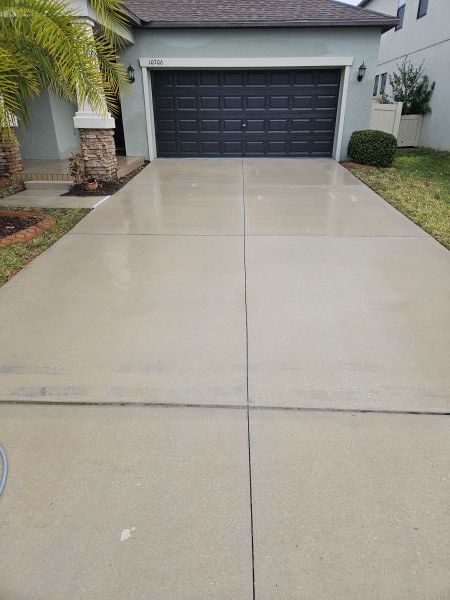 A tan stucco exterior wall under a white roof eave against a vibrant blue sky with fluffy white clouds.