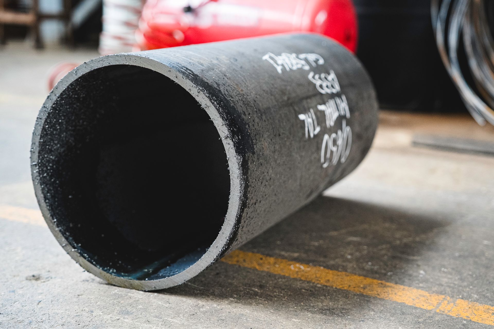 Un grande tubo nero giace a terra.