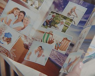 A person is holding a book with a collage of pictures on it.